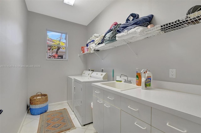 laundry room featuring separate washer and dryer, sink, light tile patterned floors, and cabinets