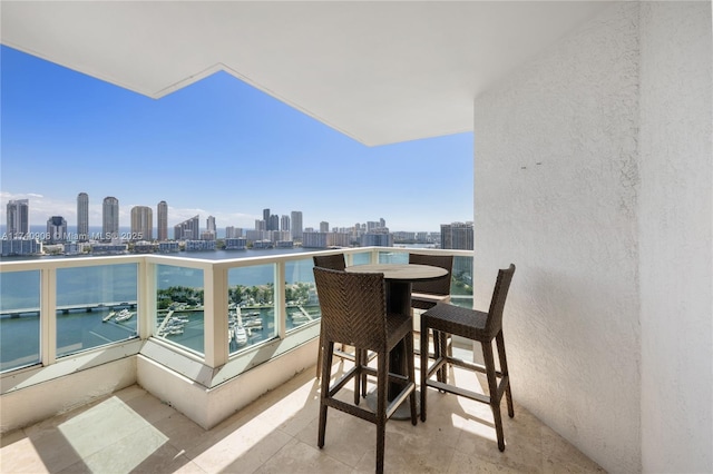 balcony with a water view and a view of city