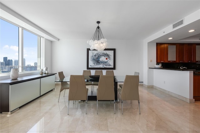 dining space featuring a city view, a notable chandelier, recessed lighting, visible vents, and baseboards