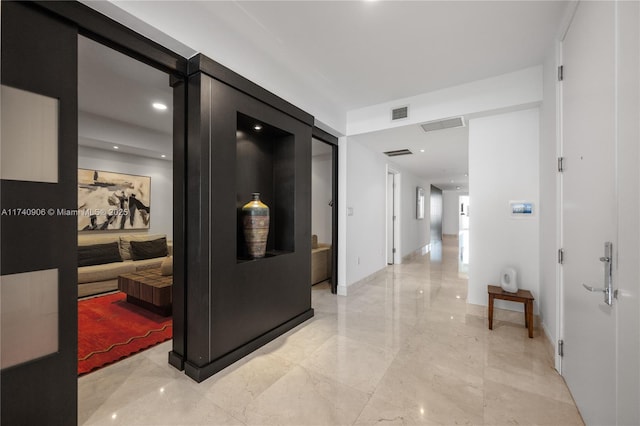 corridor featuring marble finish floor, visible vents, and baseboards