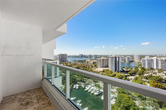 balcony featuring a water view and a city view