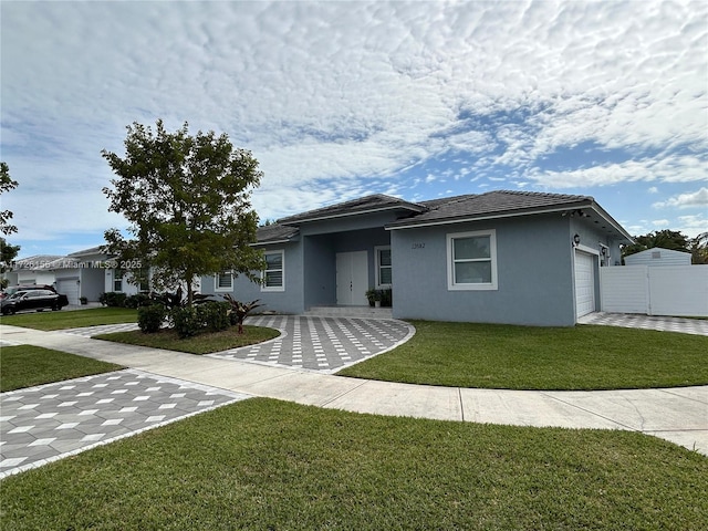 view of front of house featuring a garage and a front lawn