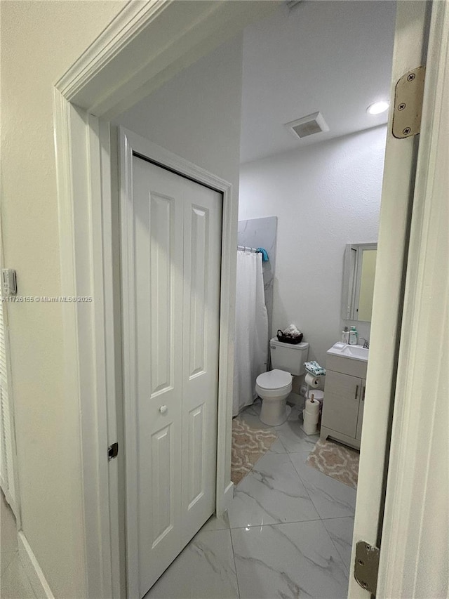 bathroom featuring vanity, curtained shower, and toilet