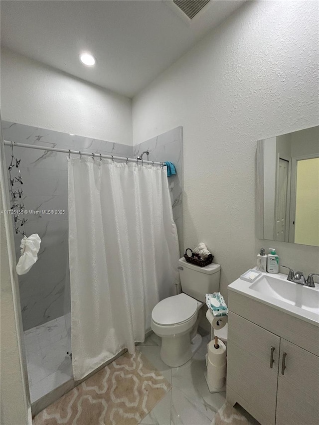 bathroom featuring walk in shower, vanity, and toilet