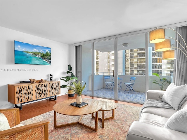 living room featuring wood-type flooring and floor to ceiling windows