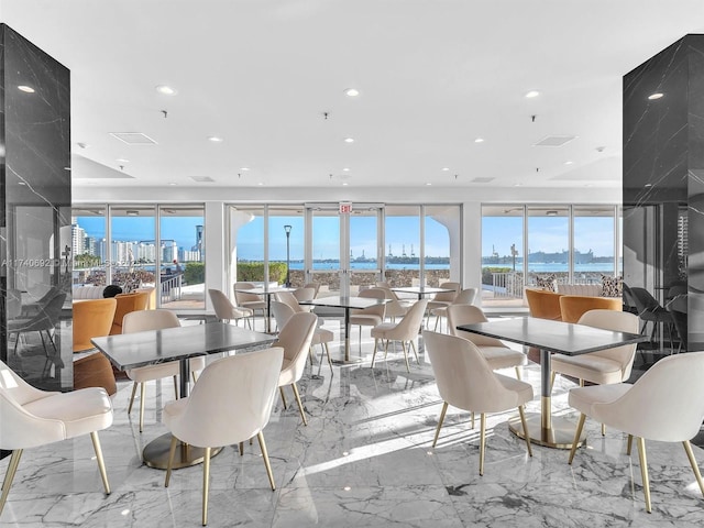 dining space featuring a water view and a healthy amount of sunlight