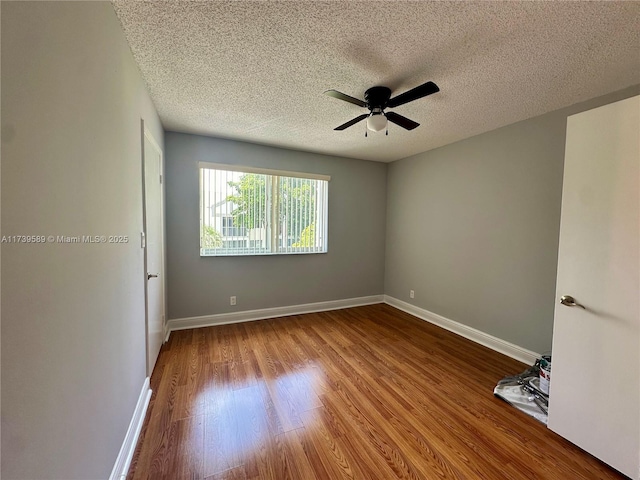 spare room featuring ceiling fan, hardwood / wood-style floors, and a textured ceiling