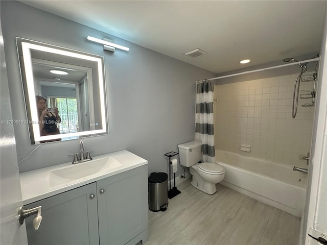 full bathroom with shower / tub combo with curtain, vanity, hardwood / wood-style floors, and toilet