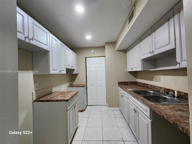 kitchen featuring white cabinetry, sink, and light tile patterned flooring