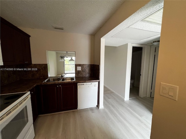 kitchen featuring white appliances, sink, a textured ceiling, and light wood-type flooring