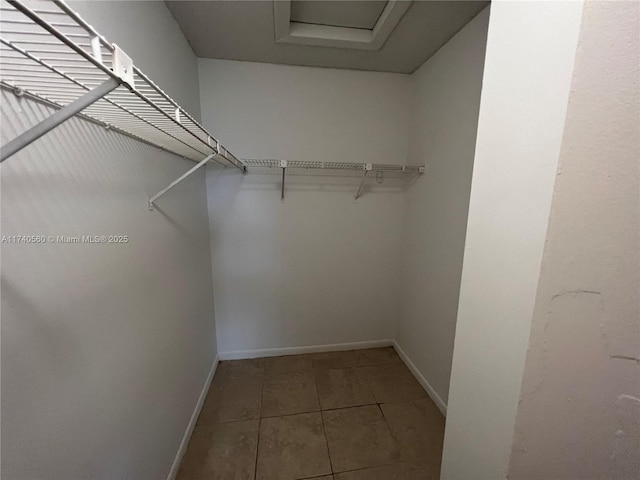 walk in closet with tile patterned floors