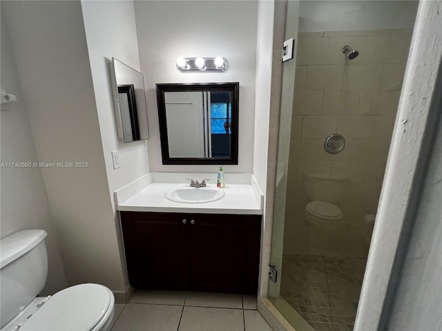 bathroom with vanity, tiled shower, tile patterned floors, and toilet