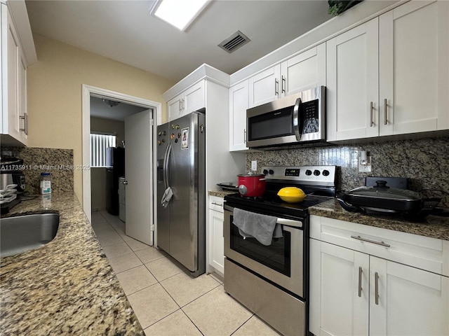 kitchen featuring white cabinetry, appliances with stainless steel finishes, stone countertops, and tasteful backsplash