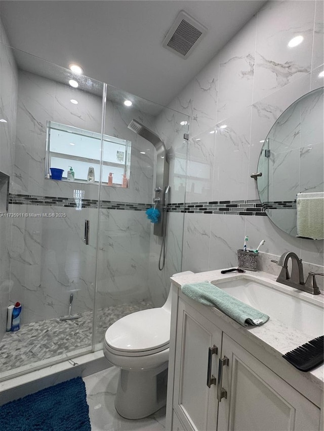 bathroom with vanity, toilet, an enclosed shower, and tile walls