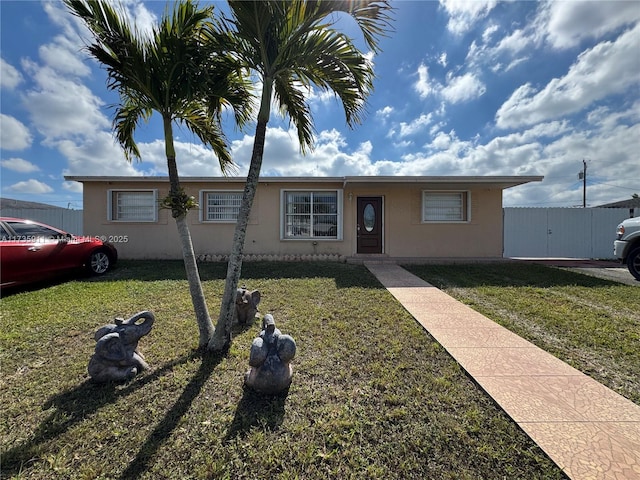 single story home featuring a front lawn