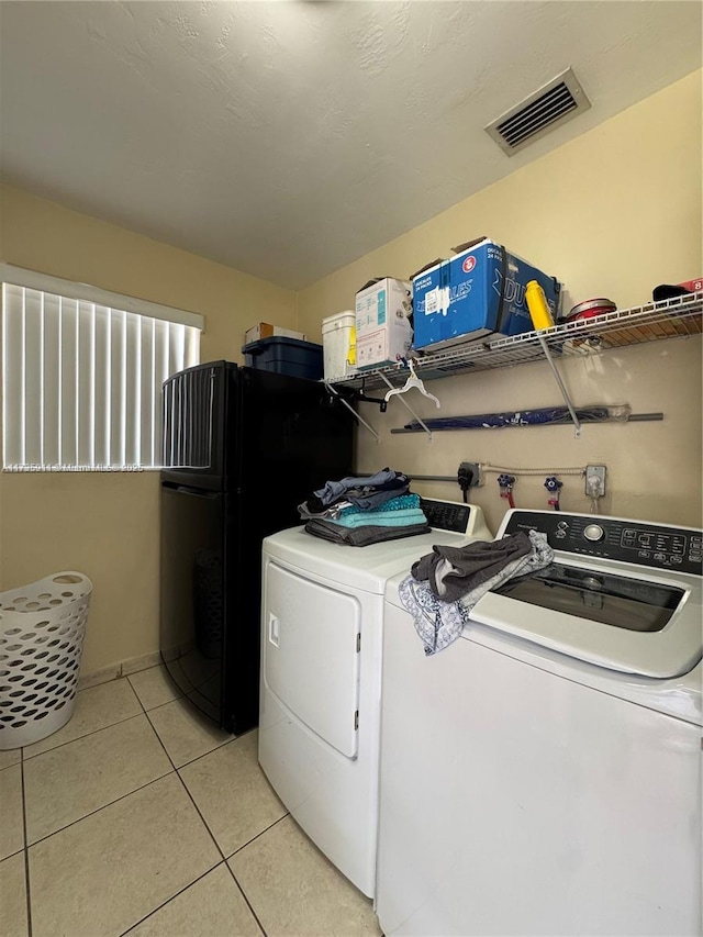 laundry room with light tile patterned floors and washing machine and clothes dryer