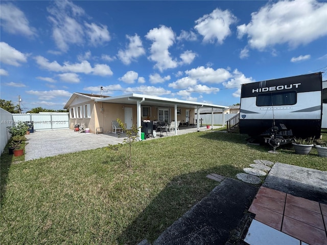 rear view of house featuring a patio and a lawn