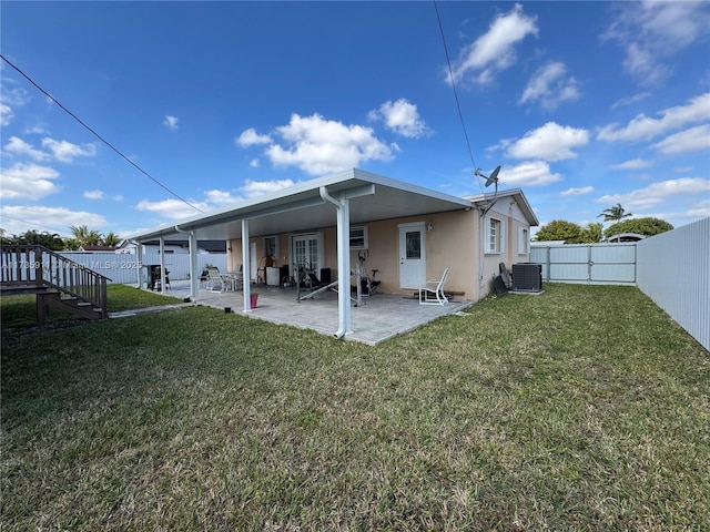 rear view of property with a yard, central AC, and a patio area