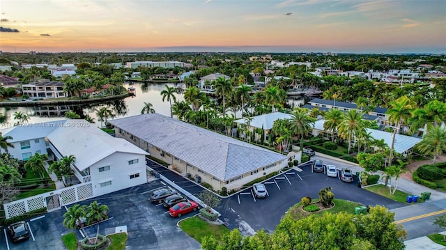 aerial view at dusk featuring a water view