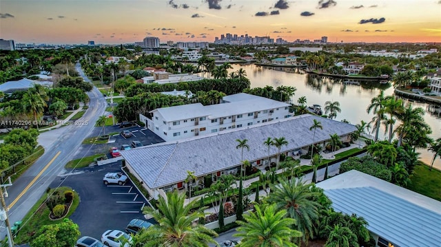 aerial view at dusk featuring a water view