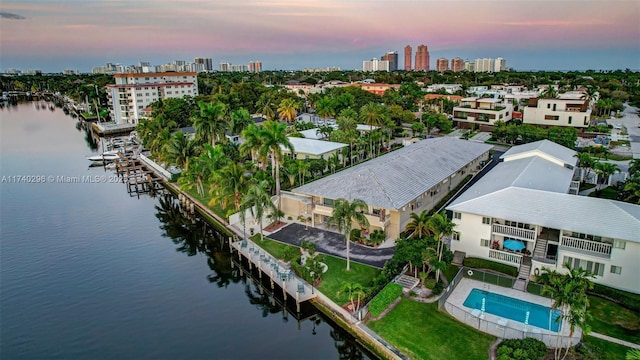 aerial view at dusk featuring a water view