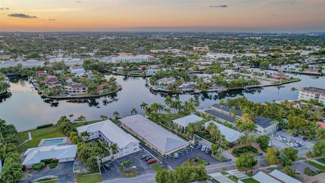 aerial view at dusk featuring a water view