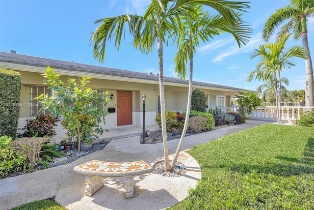 ranch-style home featuring a front yard