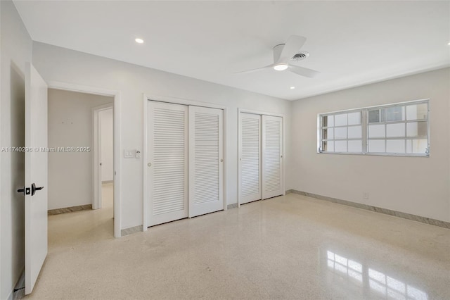 unfurnished bedroom featuring multiple closets and ceiling fan