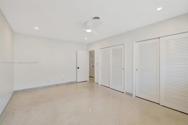 unfurnished bedroom featuring ceiling fan and multiple closets