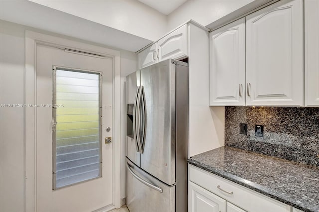 kitchen with tasteful backsplash, white cabinetry, dark stone counters, and stainless steel fridge with ice dispenser