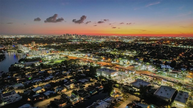 aerial view at dusk featuring a water view