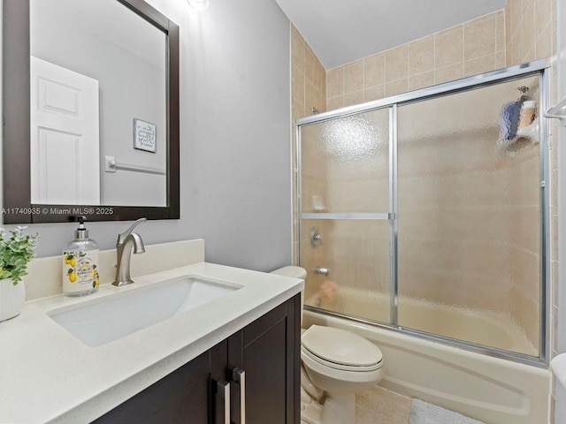 full bathroom with combined bath / shower with glass door, tile patterned flooring, vanity, and toilet