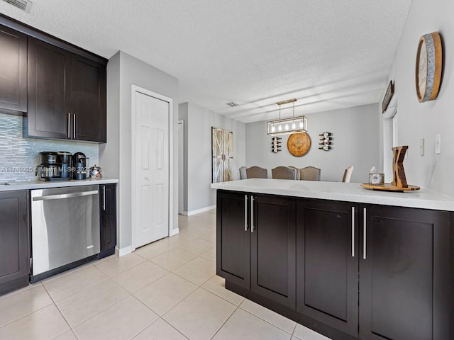 kitchen featuring tasteful backsplash, dishwasher, light countertops, and light tile patterned floors
