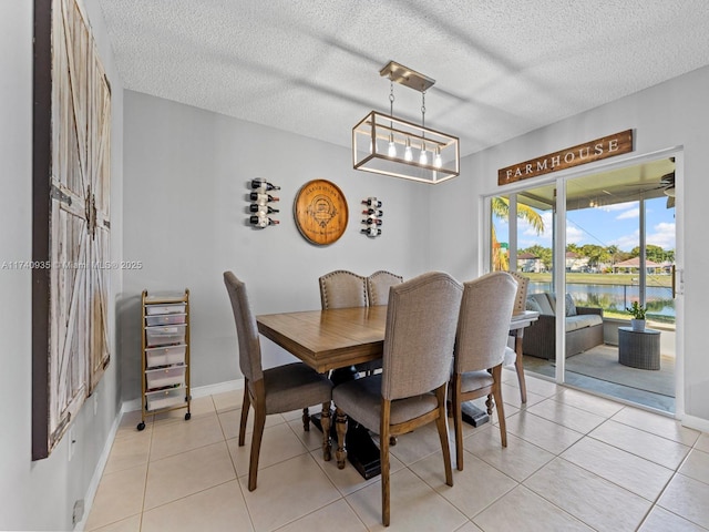 dining space with baseboards, light tile patterned flooring, and a textured ceiling