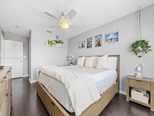 bedroom featuring ceiling fan, dark wood-type flooring, and a textured ceiling