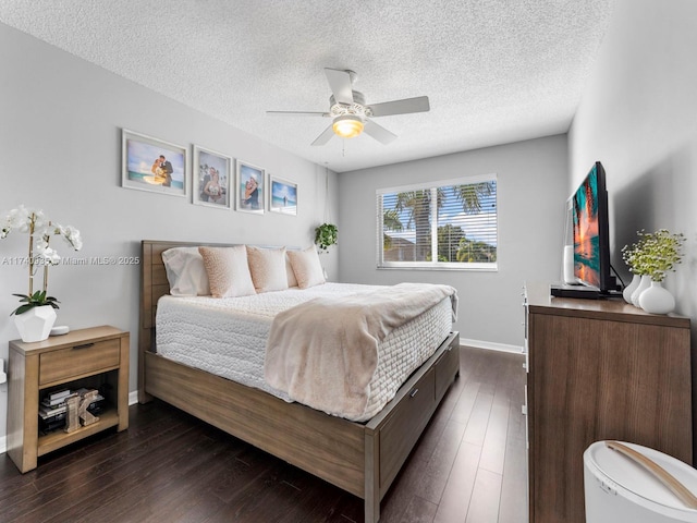 bedroom with a ceiling fan, baseboards, a textured ceiling, and dark wood finished floors