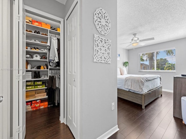 bedroom featuring ceiling fan, dark hardwood / wood-style floors, a textured ceiling, and a closet