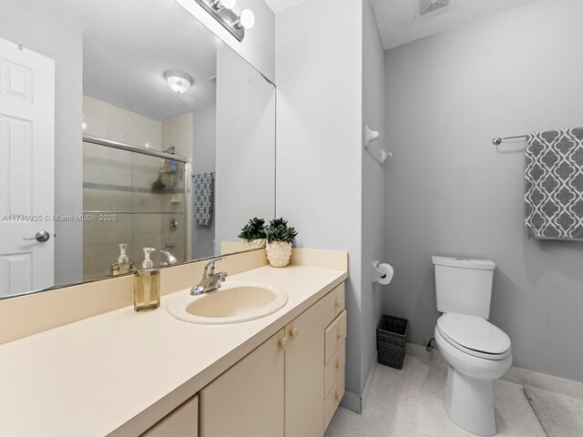 full bathroom with vanity, baseboards, a stall shower, tile patterned flooring, and toilet