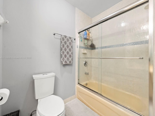 bathroom featuring bath / shower combo with glass door and toilet