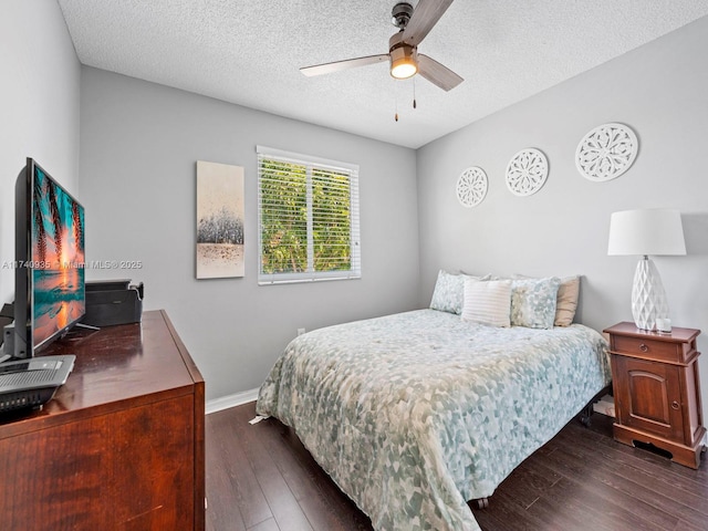 bedroom with a ceiling fan, baseboards, a textured ceiling, and dark wood finished floors