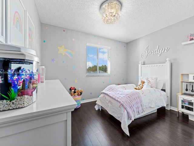 bedroom featuring dark wood-type flooring, an inviting chandelier, and a textured ceiling