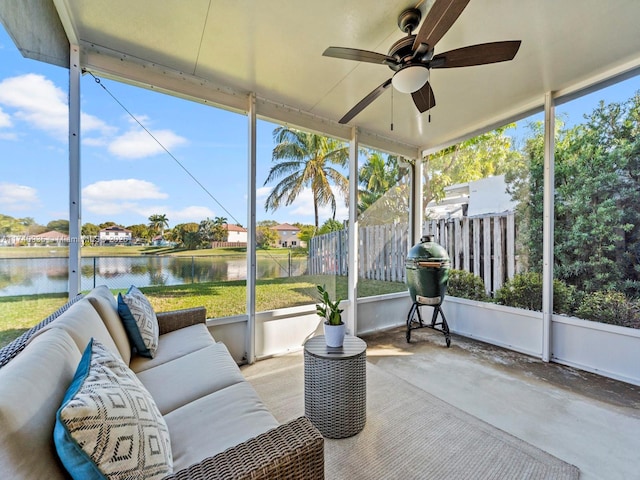 sunroom / solarium with ceiling fan and a water view