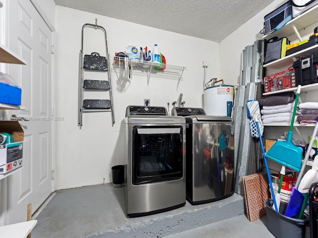 clothes washing area featuring a textured ceiling, washer and clothes dryer, laundry area, and water heater