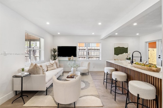 living room with beam ceiling and light hardwood / wood-style flooring