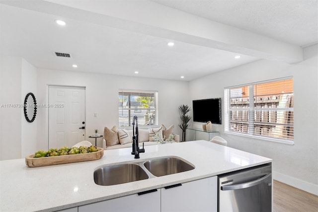 kitchen featuring sink, light stone counters, white cabinetry, light hardwood / wood-style flooring, and dishwasher