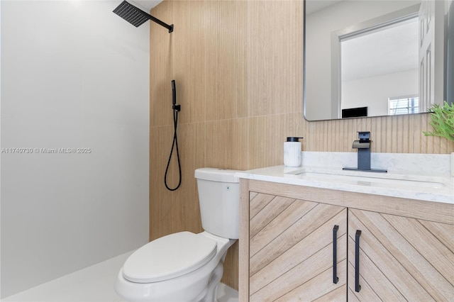 bathroom featuring vanity, a shower, tile walls, and toilet