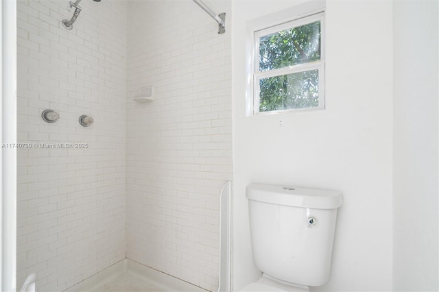 bathroom featuring toilet and a tile shower