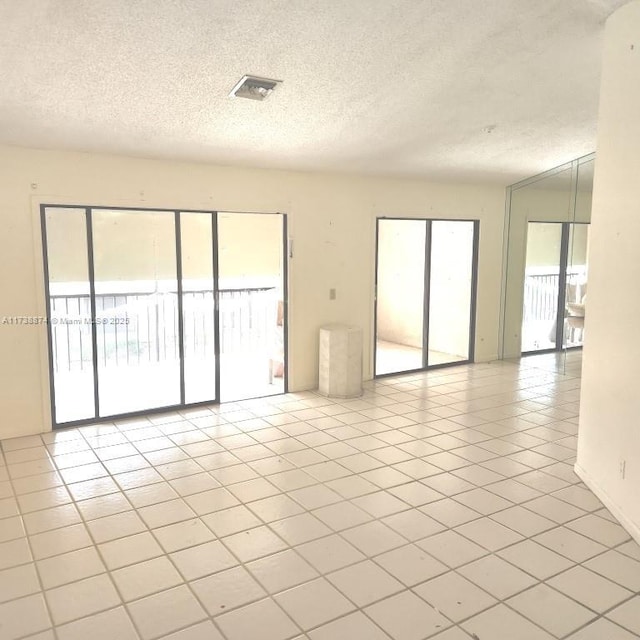 empty room featuring light tile patterned flooring and a textured ceiling