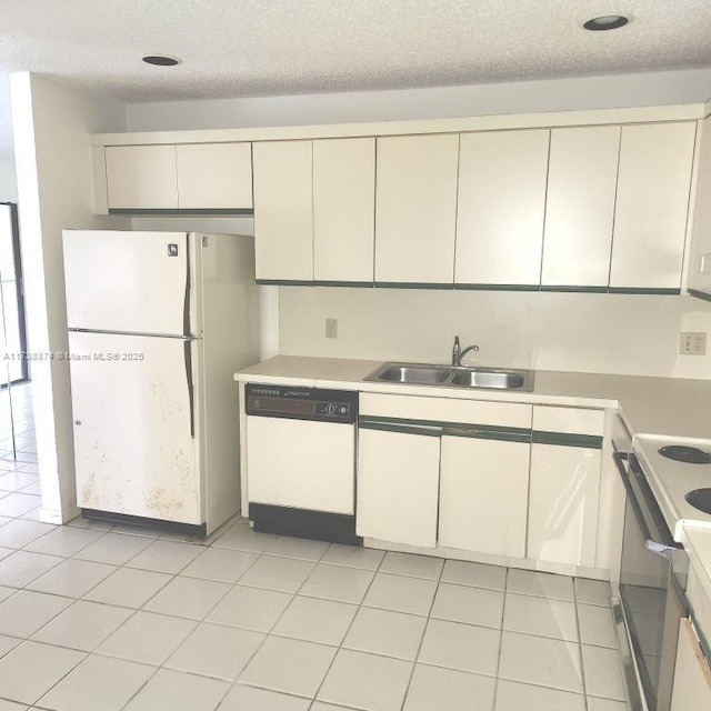 kitchen with light tile patterned floors, a textured ceiling, white appliances, a sink, and light countertops