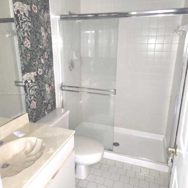 full bath featuring a stall shower, tile patterned flooring, vanity, and toilet